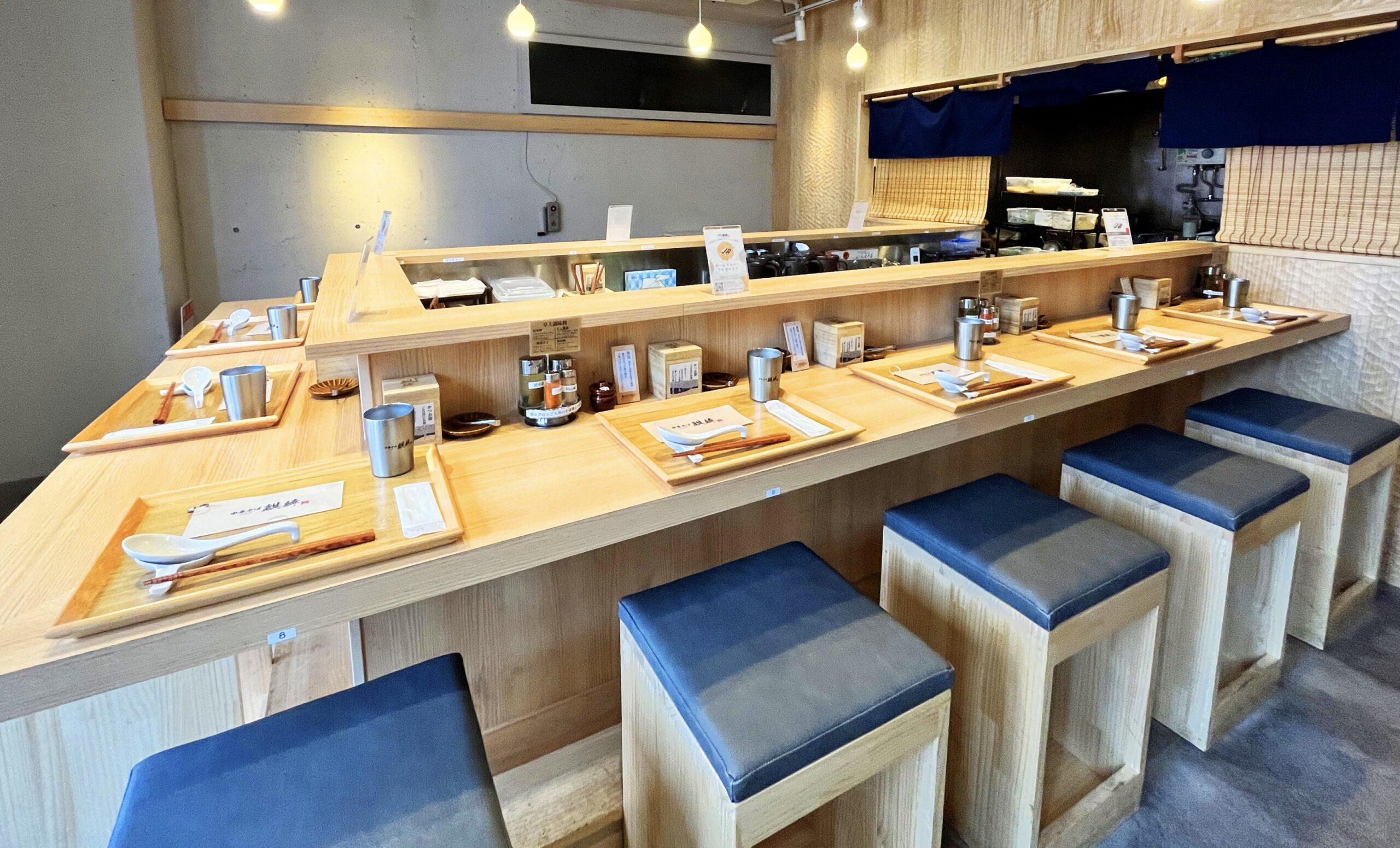 中華そば麒麟の店内風景 - 木目調のカウンター席と青いクッションが並ぶ上品な空間